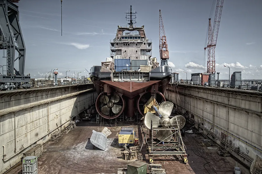 Schiff im Trockendock während des Neubaus, mit Propelleranlagen und Bugstrahlrudern
